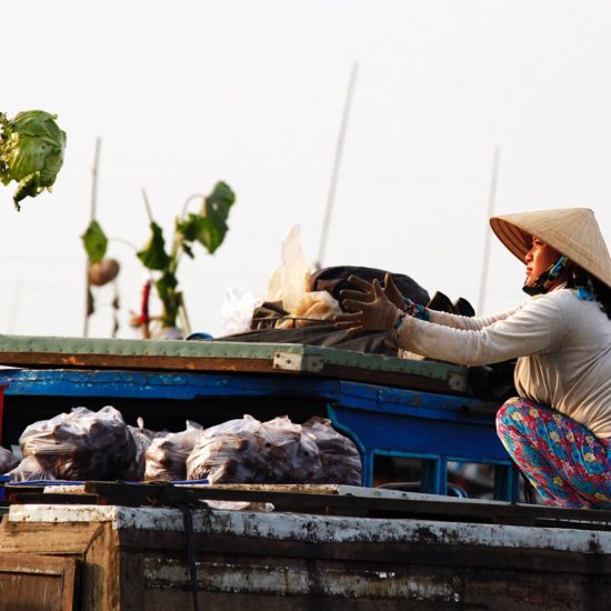 Femme sur le marché flottant de Cai Be, Delta du Mékong, Vietnam