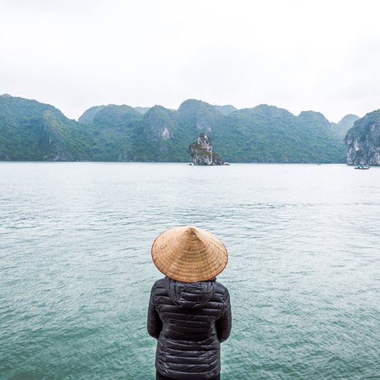 Cliente portant le chapeau vietnamien traditionnel dans la Baie d'Halong, Vietnam