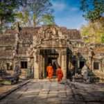 Moines entrant dans les ruines d'un des temples du site d'Angkor