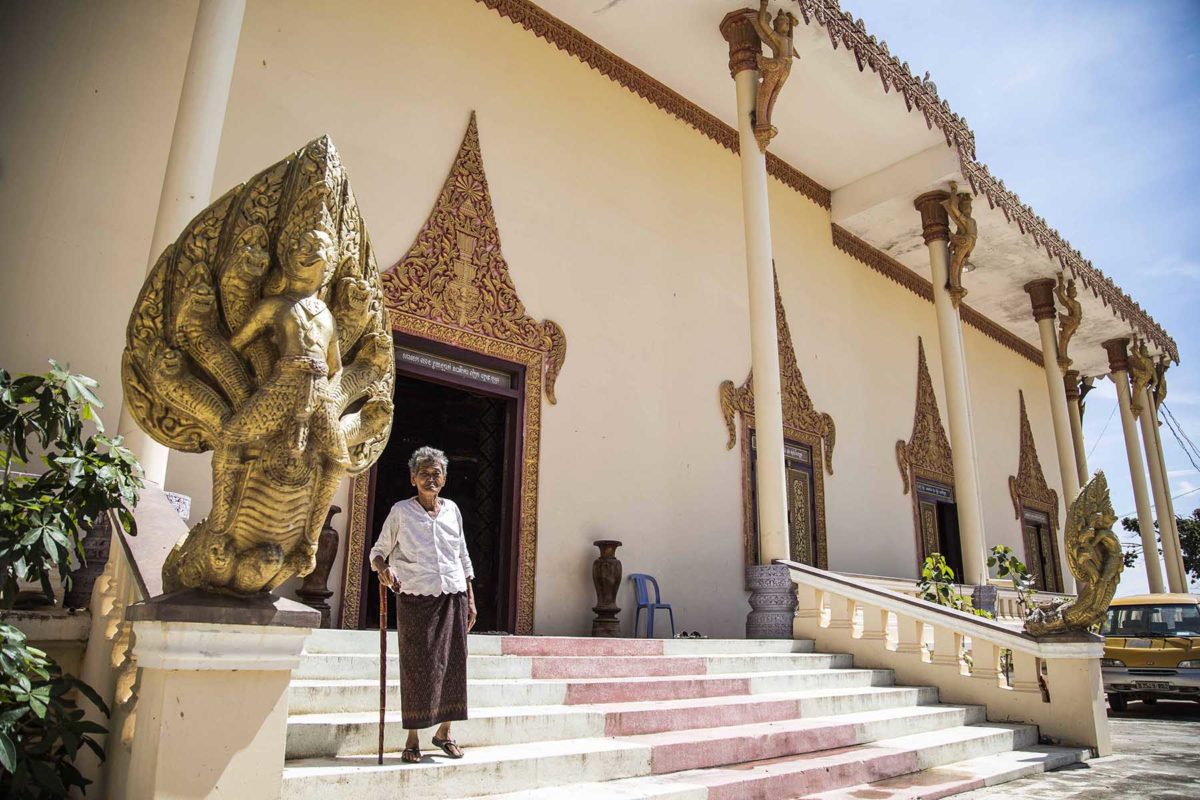 Une vieille femme devant un temple au Cambodge