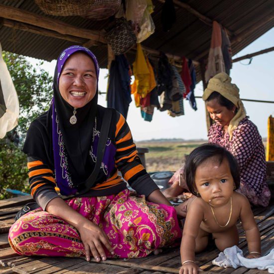 Mère de famille Khmer de confession musulmane souriant devant sa maison, Cambodge