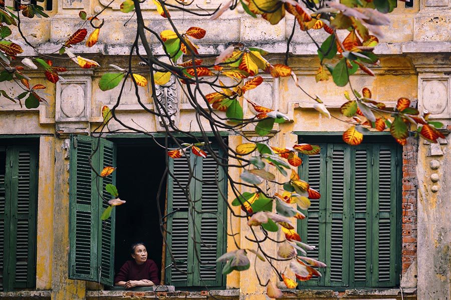 Habitant du vieux quartier de Hanoi à sa fenêtre