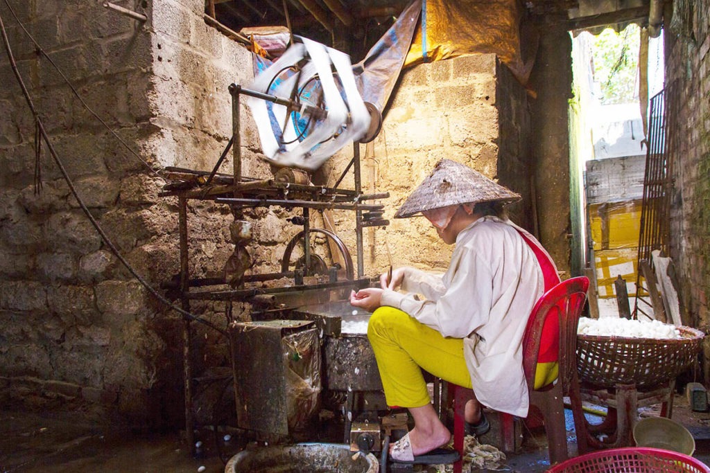 Une femme fabriquant les fibres de soie chez elle, Vietnam