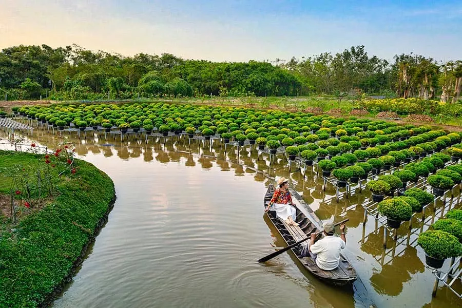 Couple naviguant sur un petit bateau au milieu des plantes d'eau dans le delta du Mékong