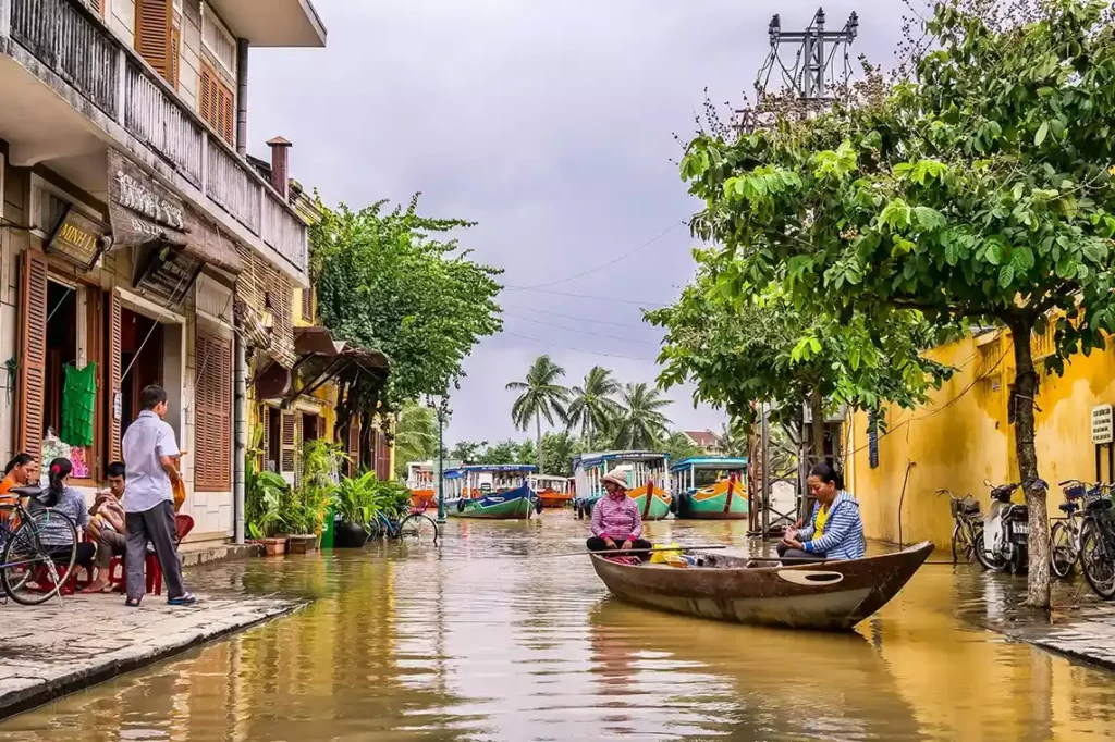 Personnes en barque dans les rues de Hoi An inondée